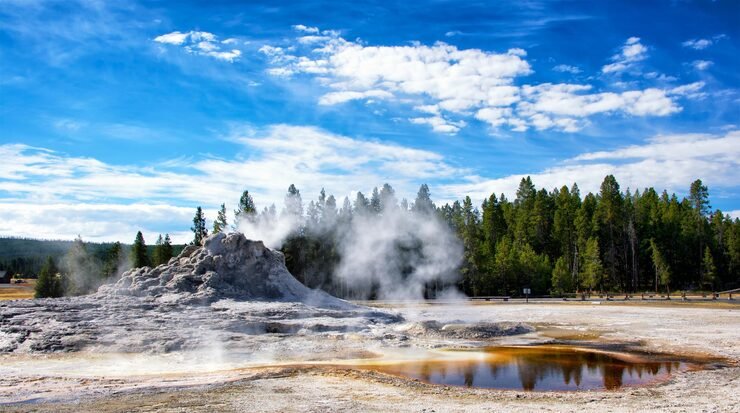 steam emitting from geyser against sky yellowstone national park 1048944 23525759